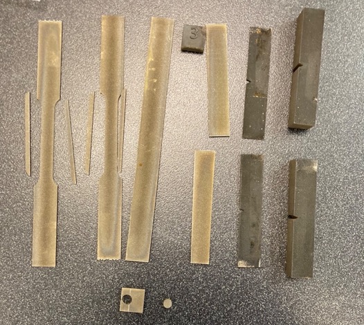 A group of co-printed tensile sample materials showing wear and tear