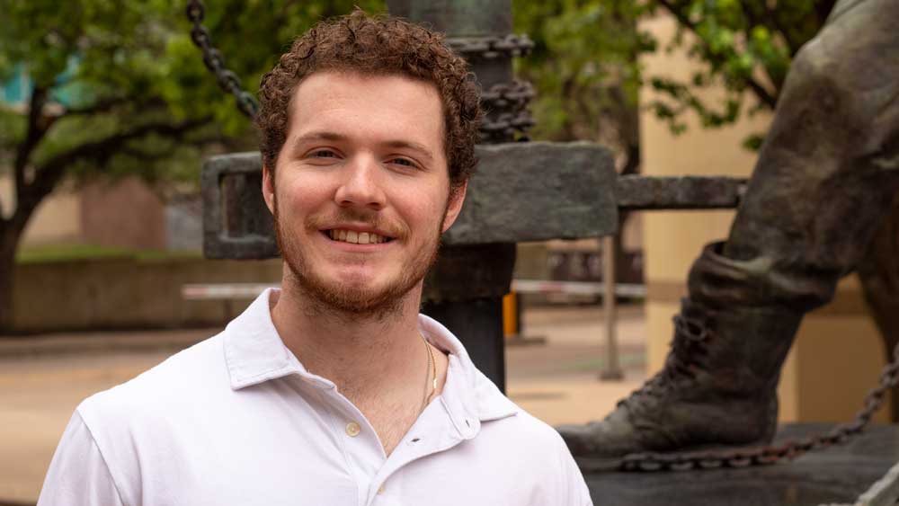 male student smiling and standing outdoors on Texas A&M University campus