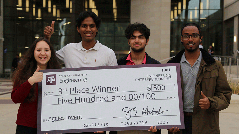 Group posing with big check.